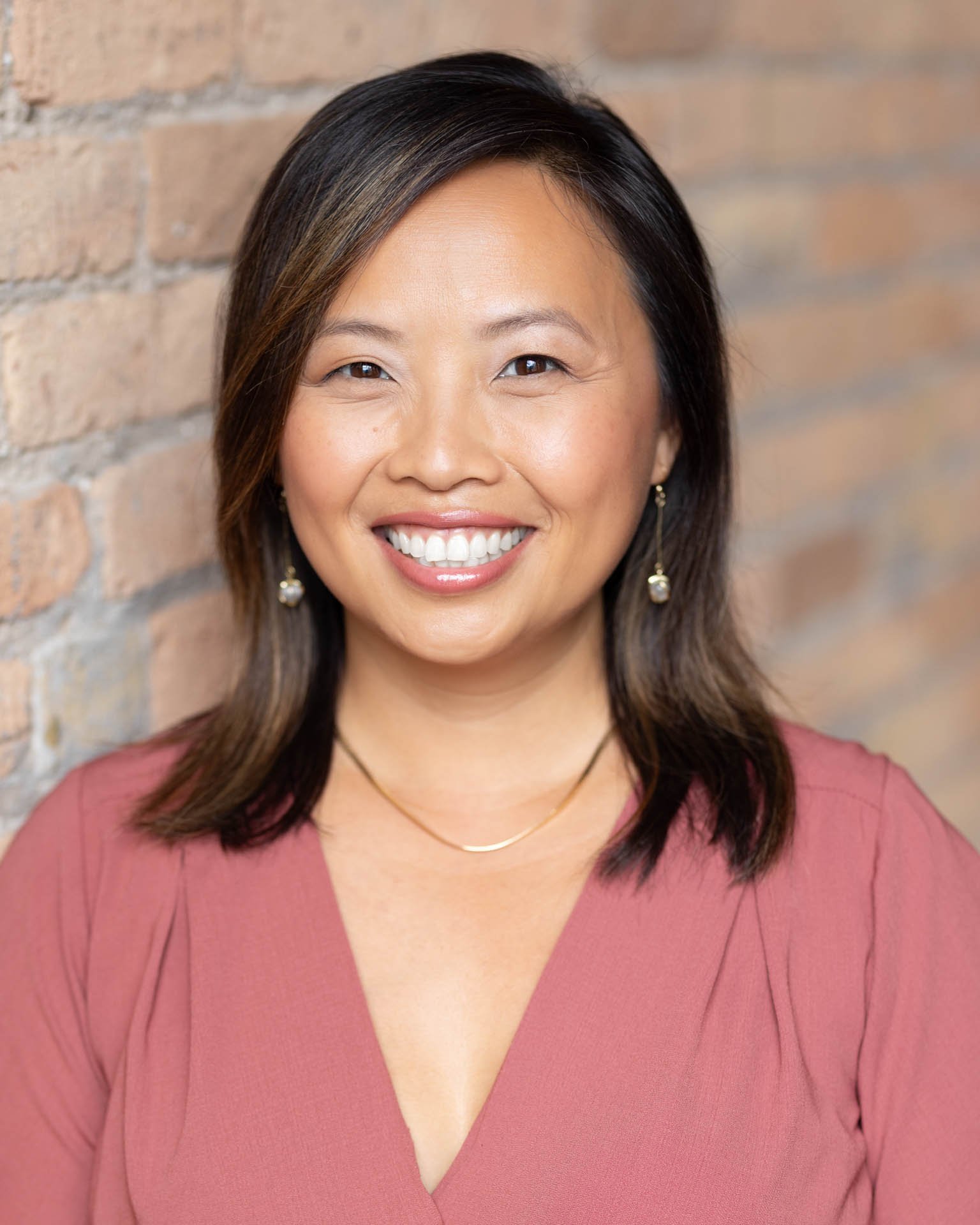 Professional headshot of young and vibrant Asian woman smiling