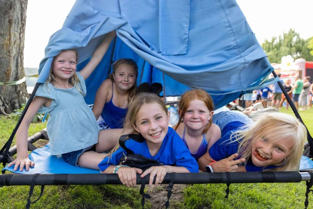 Photo from a benefit celebration hosted by a nonprofit of young girls smiling on a swing