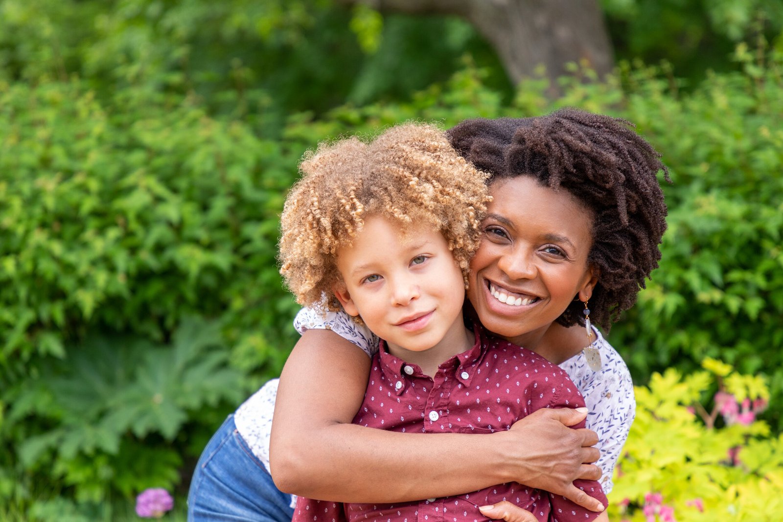 Beautiful Black Woman and mixed race son pose for their spring mini session at Lyndale Park Rose Garden